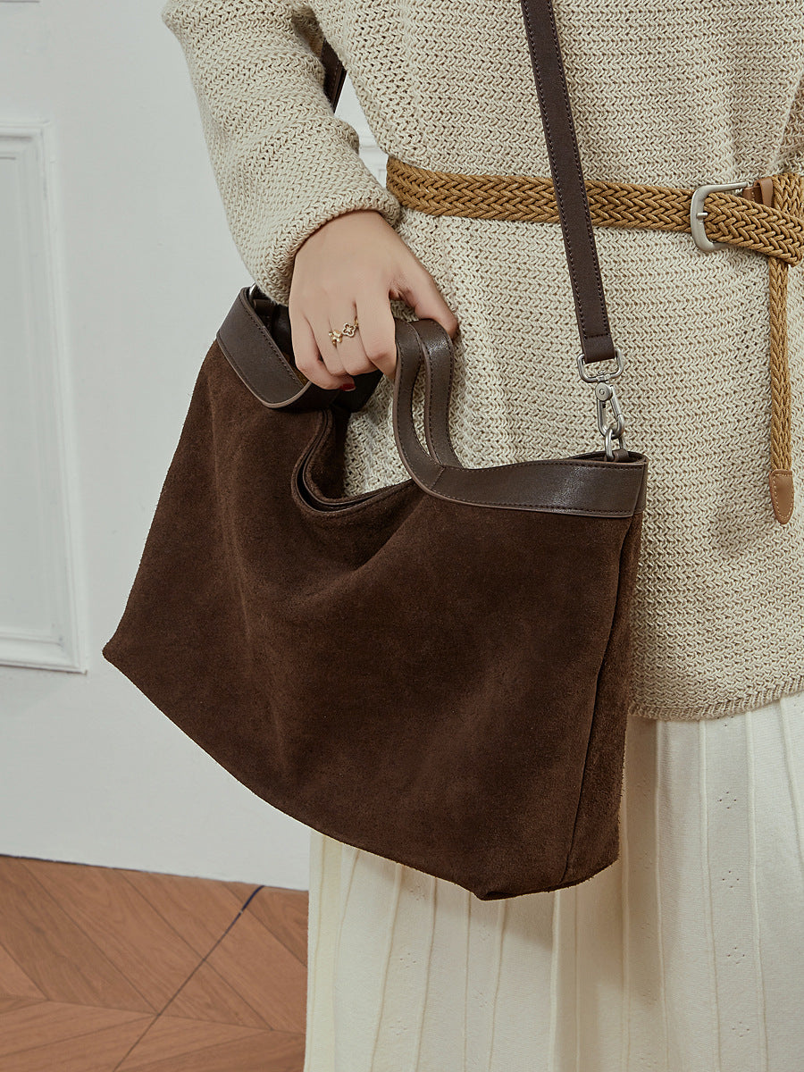 Top handle and adjustable strap detail of leather crossbody bag