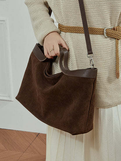 Top handle and adjustable strap detail of leather crossbody bag