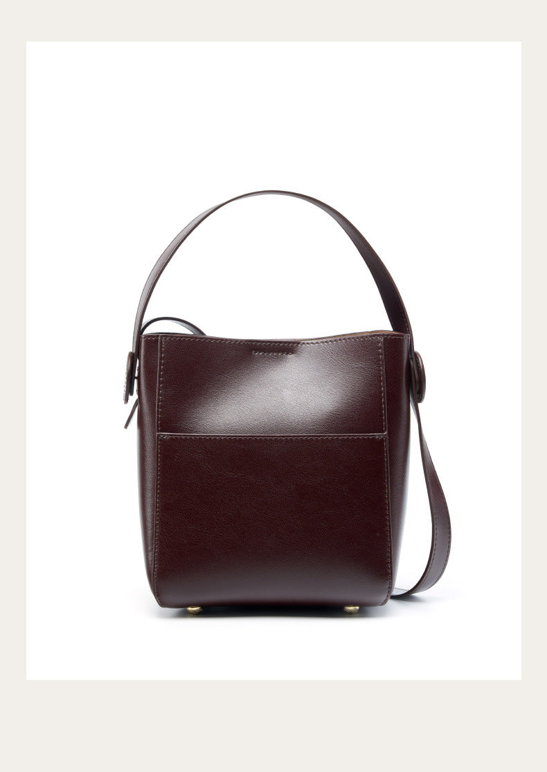 Coffee brown leather bucket bag viewed from the front on a white background