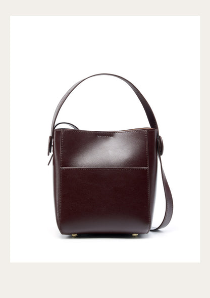 Coffee brown leather bucket bag viewed from the front on a white background