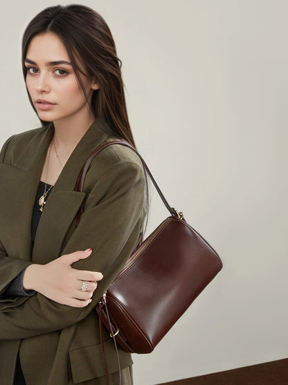 Model with coffee brown leather crossbody bag over the shoulder