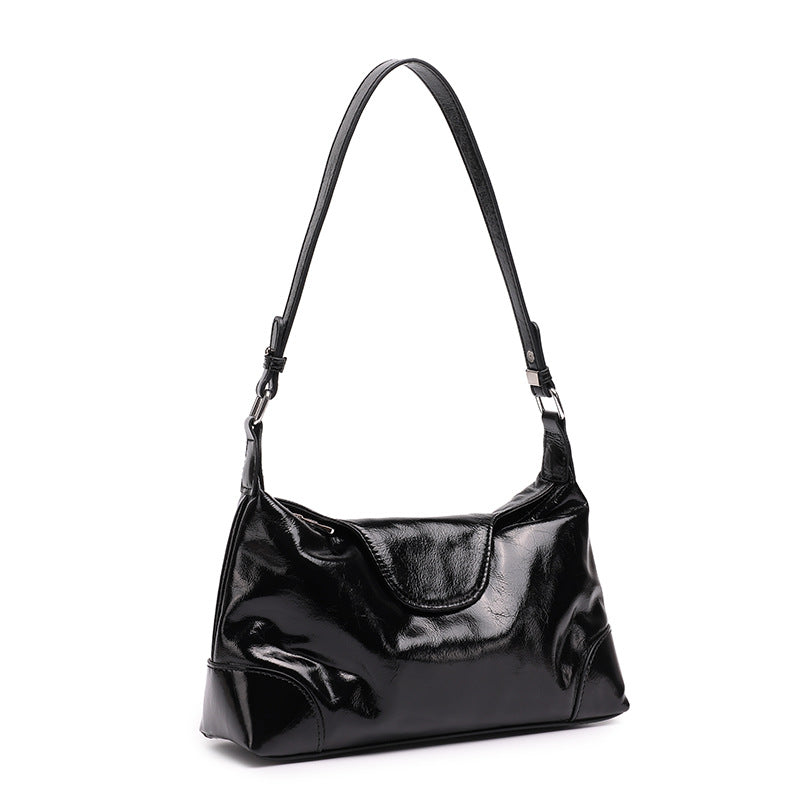Black cowhide leather shoulder bag with adjustable strap on white background