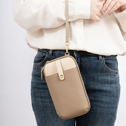 Side view of beige leather phone bag worn crossbody over a cream blouse and jeans