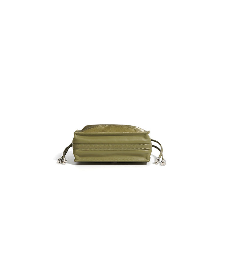 Top-down view of sage green mini bucket bag with flat lay composition