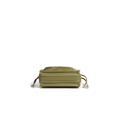 Top-down view of sage green mini bucket bag with flat lay composition