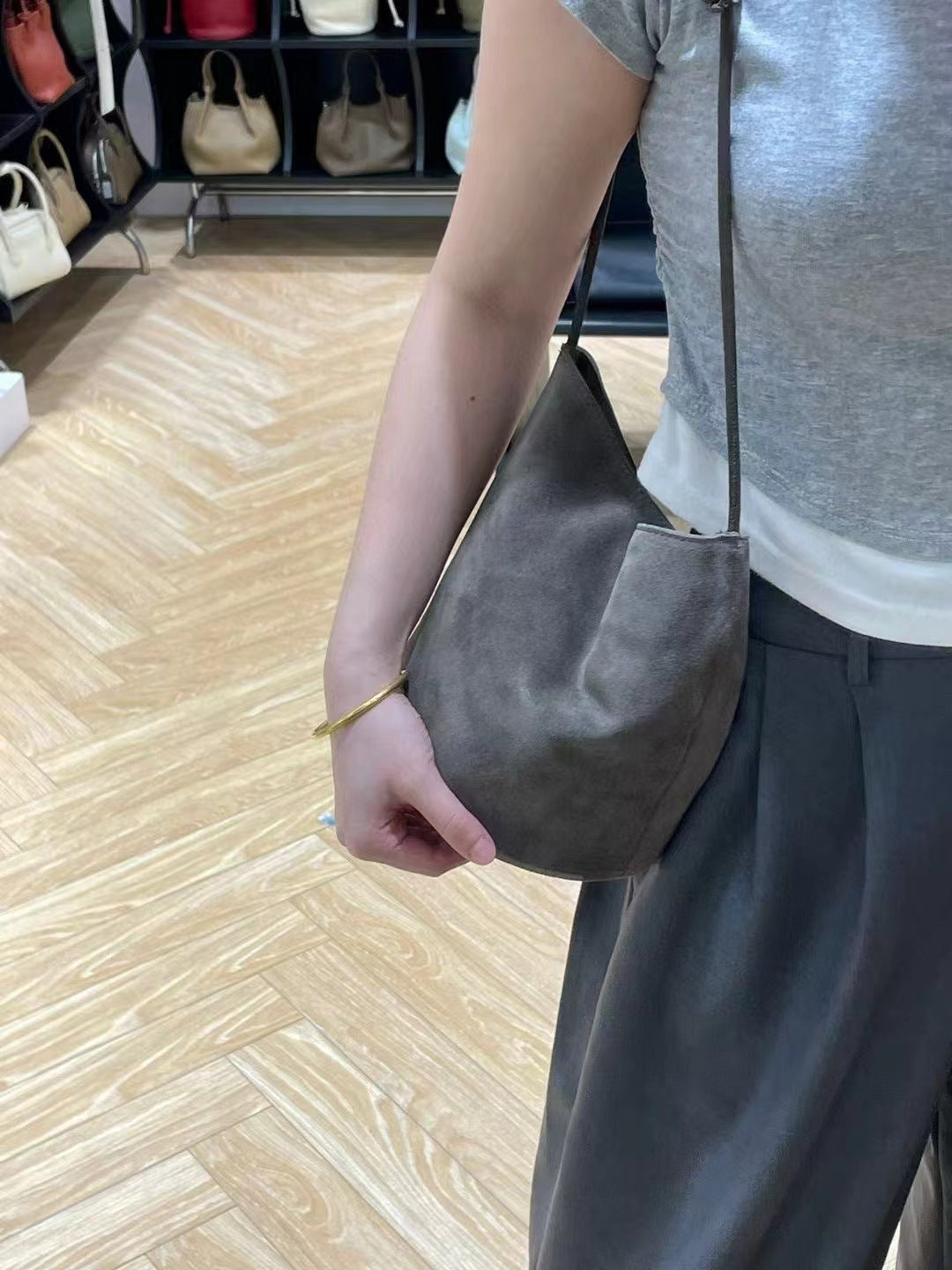 Gray bucket bag worn at the side