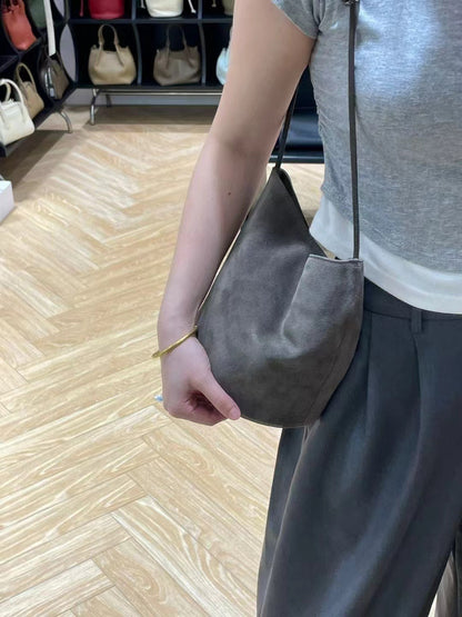 Gray bucket bag worn at the side