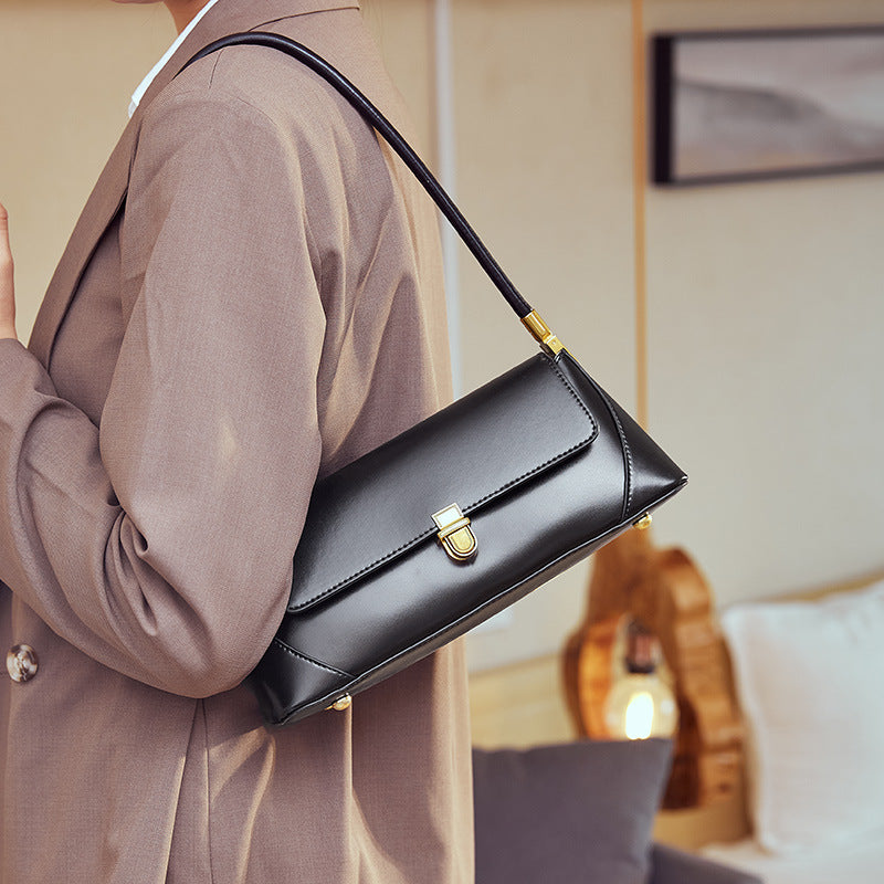 Black baguette shoulder bag styled with neutral outerwear