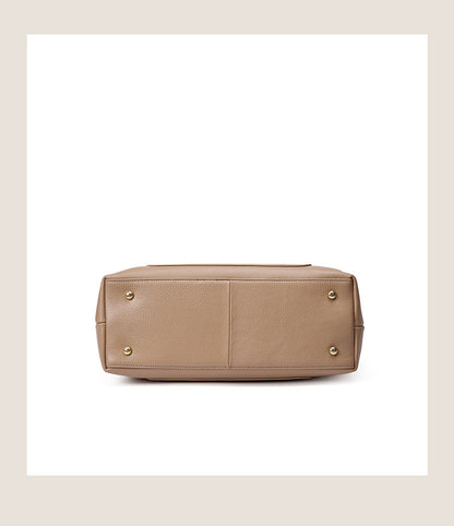 Bottom view of leather tote showing four protective metal feet