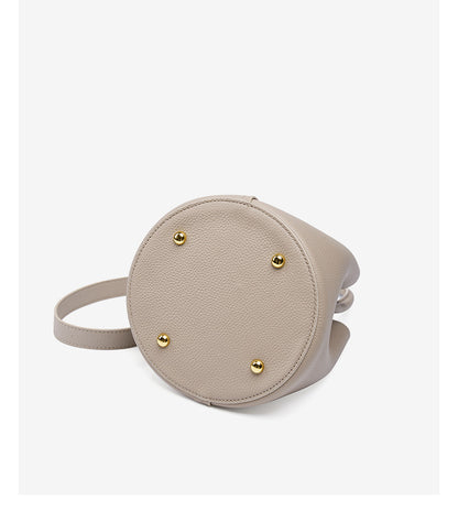Bottom view of bucket bag showing four gold-tone metal feet