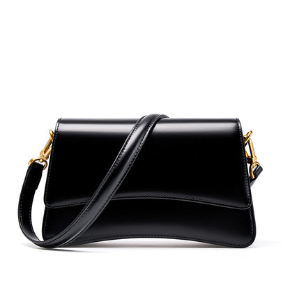 Front view of black cowhide leather mini shoulder bag with flap closure and dual straps on white background