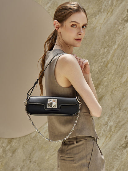 Model wearing black leather baguette shoulder bag over the shoulder