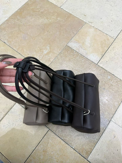 Black, gray, and ebony shoulder bags displayed together