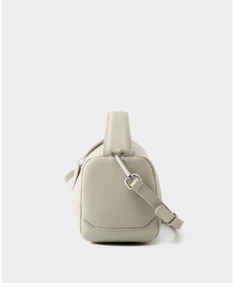 Side gusset view of ash white mini Boston bag showing D-ring hardware