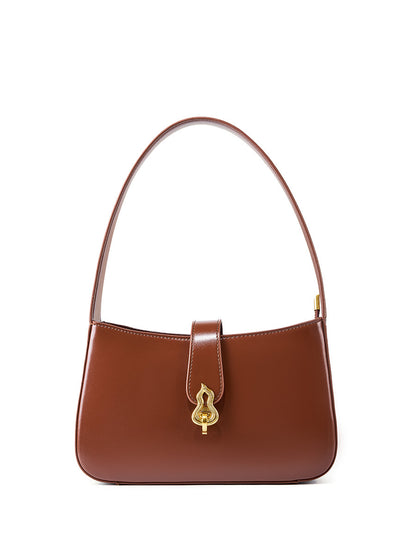 Coffee brown leather shoulder bag with gold lock clasp on white background