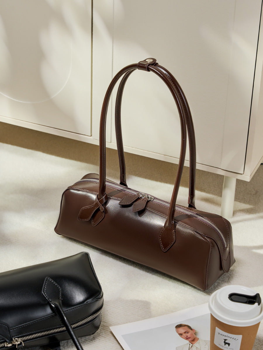 Coffee leather baguette bag styled on floor with accessories
