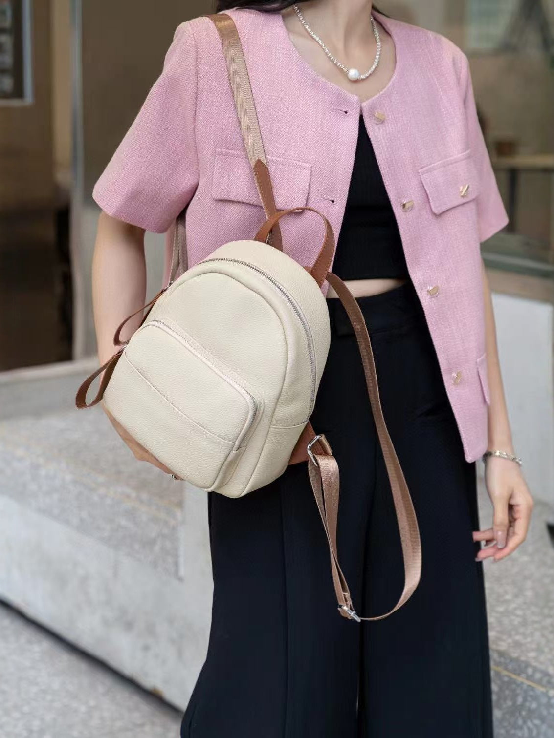 Khaki mini backpack styled on the back