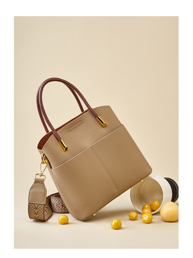 Gray bucket bag styled with a ceramic vase and yellow plums