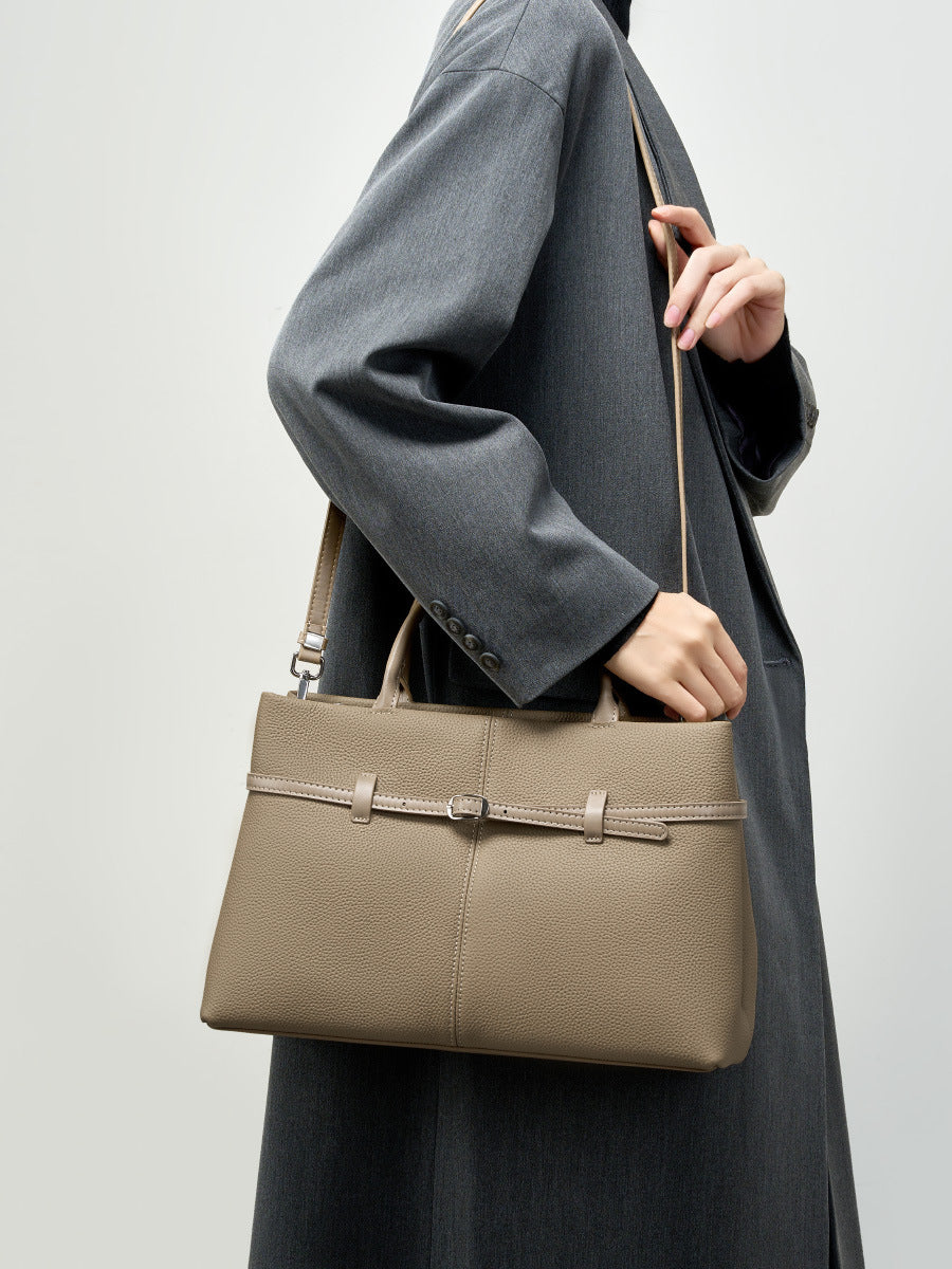 Side view of model carrying elephant gray cowhide tote on shoulder