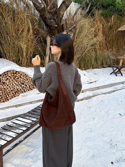 Brown shoulder tote carried with a knit sweater