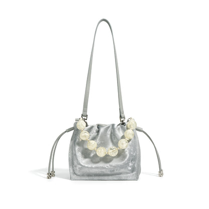 Silver metallic cowhide mini bucket bag with beaded top handle on white background