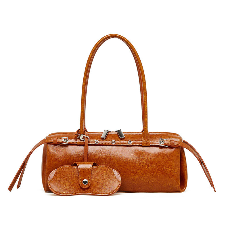 Front view of tan cowhide leather barrel tote bag on white background