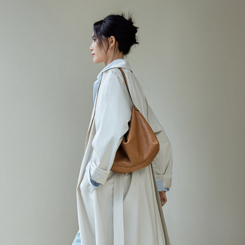 Caramel leather hobo bag shown on shoulder in profile
