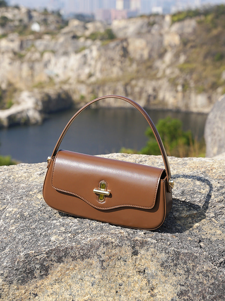 Adjustable shoulder strap of caramel leather baguette bag