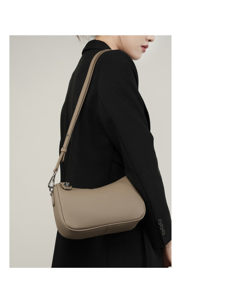 Model wearing taupe bag at hip on shoulder strap