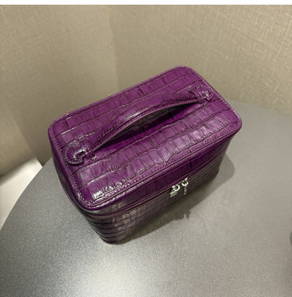 Rear panel of a purple top-handle cosmetic pouch