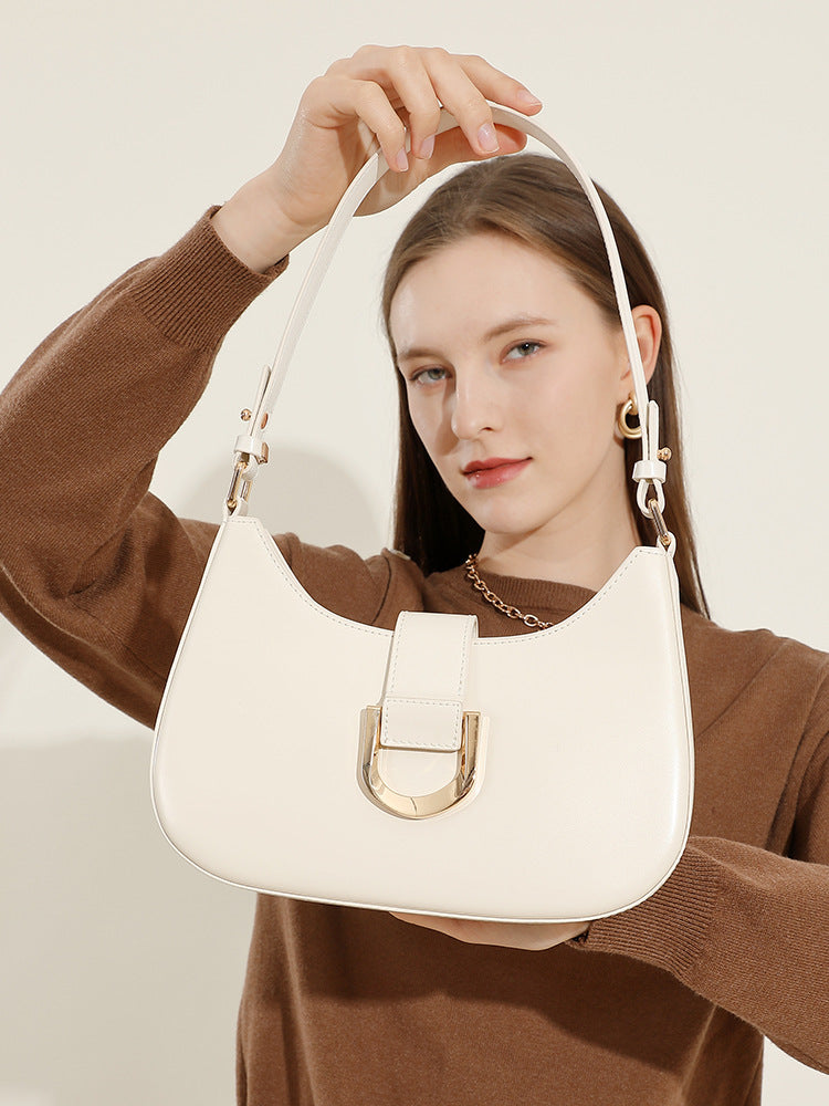 Close-up of cream white shoulder bag held by hand