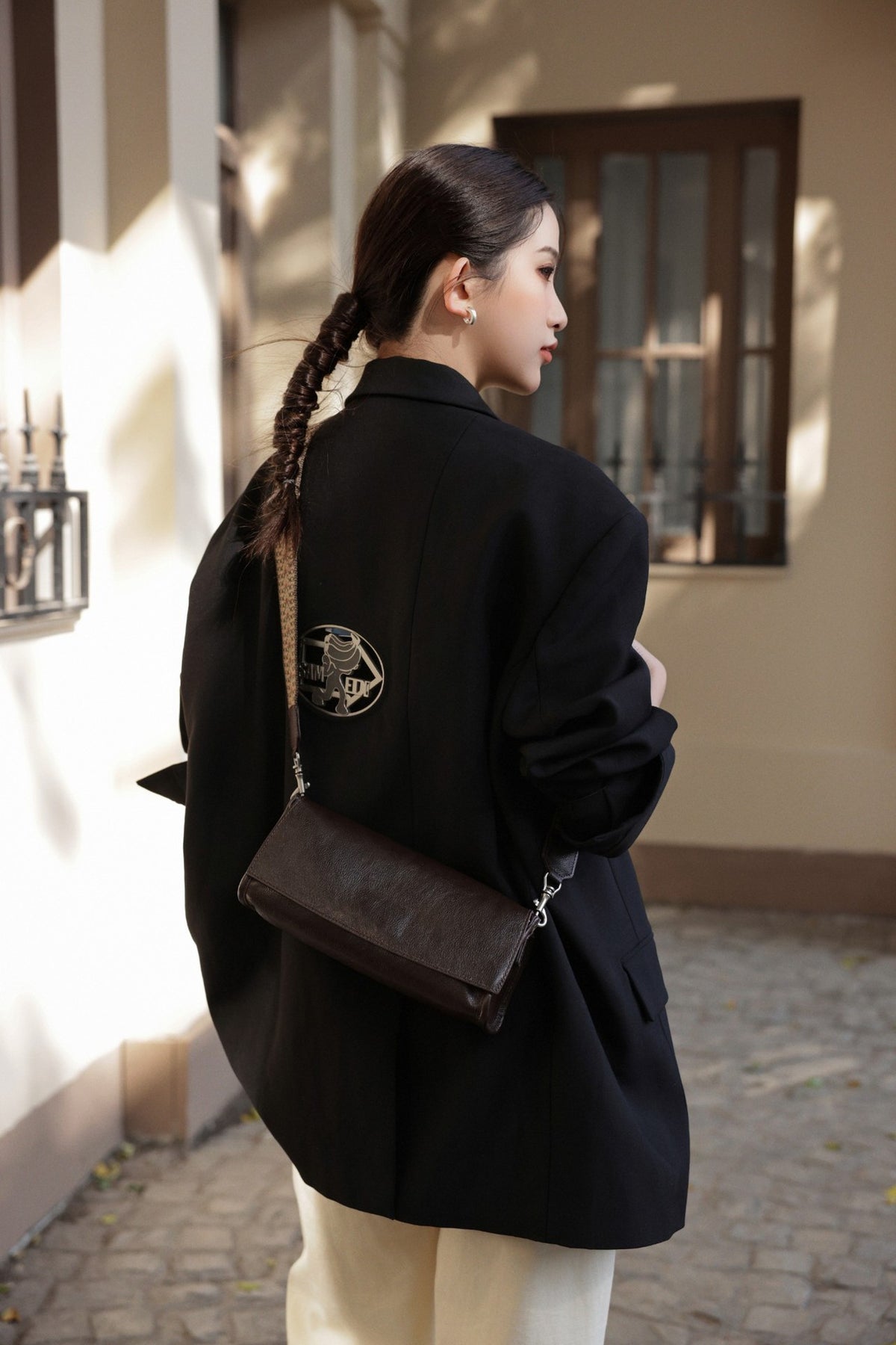 Coffee leather bag hanging beside a window