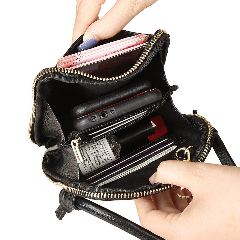 Interior view of black crossbody phone bag showing card slots, zip pocket, and compartments