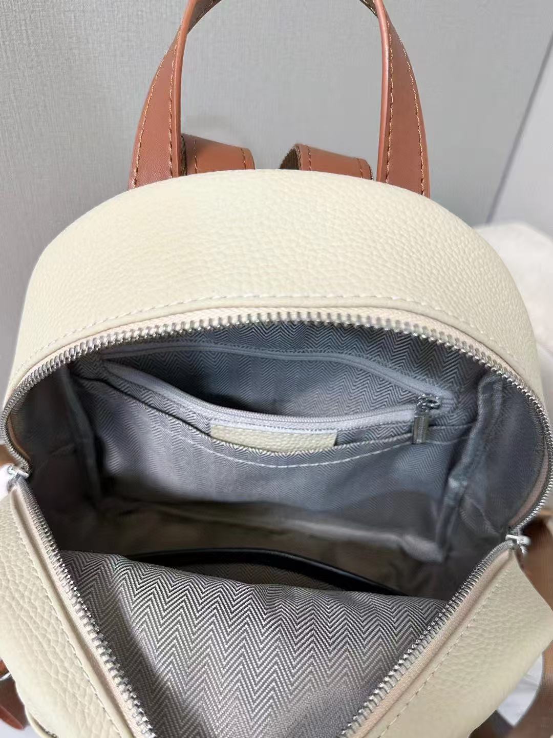Open ivory backpack showing its lined interior pockets