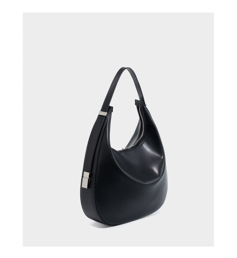 Three-quarter view of the black cowhide leather crescent hobo bag highlighting the curved silhouette and adjustable strap