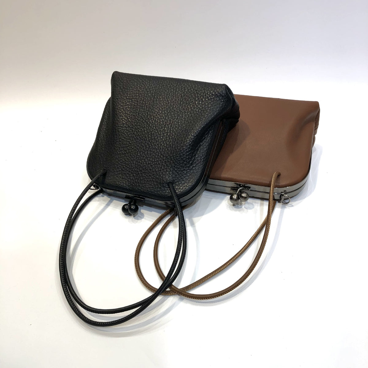 Black and coffee leather frame bags displayed together