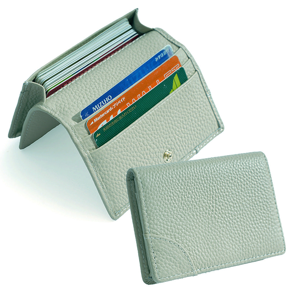 Open pale green cowhide card holder revealing interior card slots and metal snap