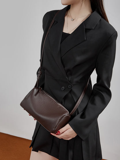 Close-up of the zip top and pebbled grain on the coffee leather barrel bag