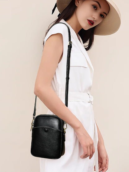 Model wearing black cowhide leather mini crossbody bag with white outfit