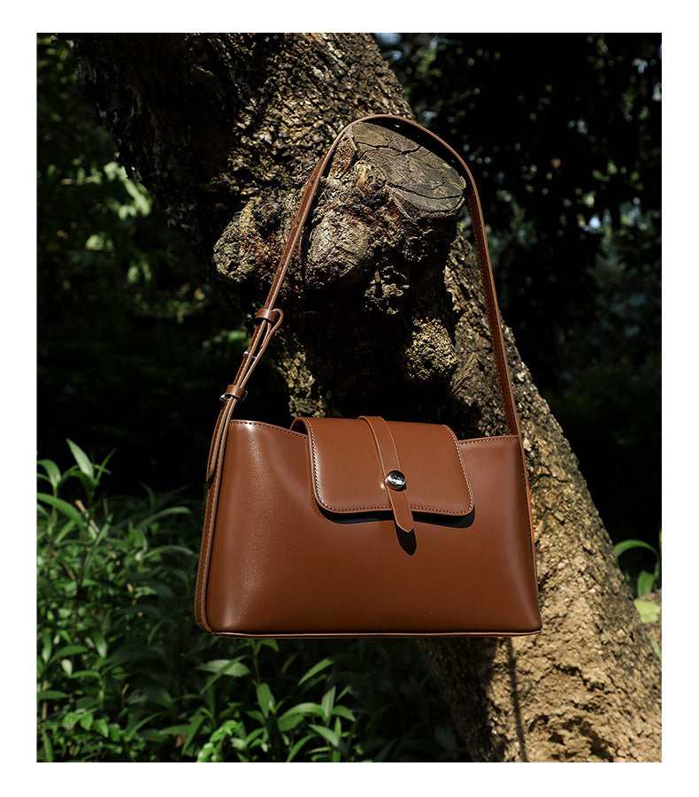 White leather bag hanging on tree branch close-up