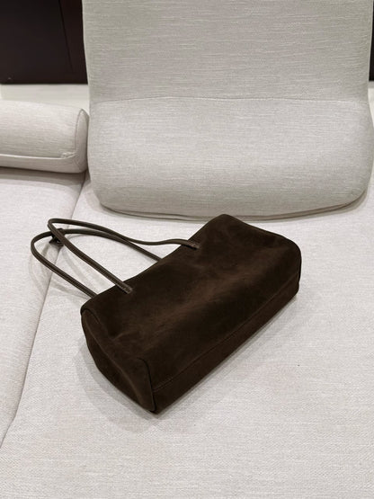 Dark tote shown at an angle to highlight its soft silhouette