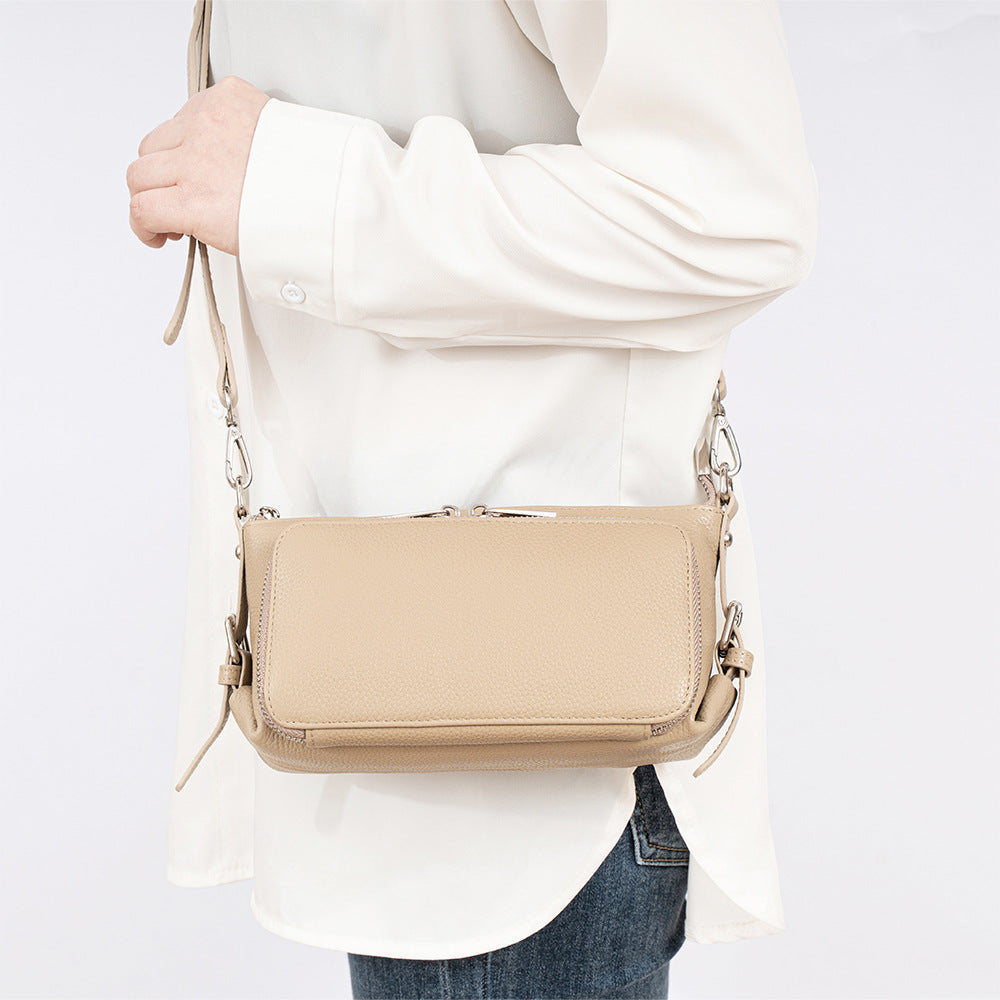 Black leather bag displayed on model in casual outfit