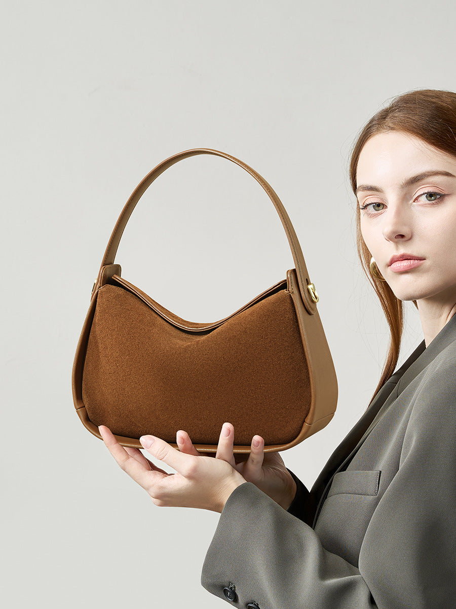 Front view of a brown suede pillow-shaped shoulder bag