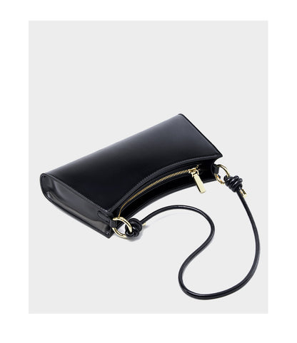 Black leather underarm bag with strap extended showing gold-tone rings and knots