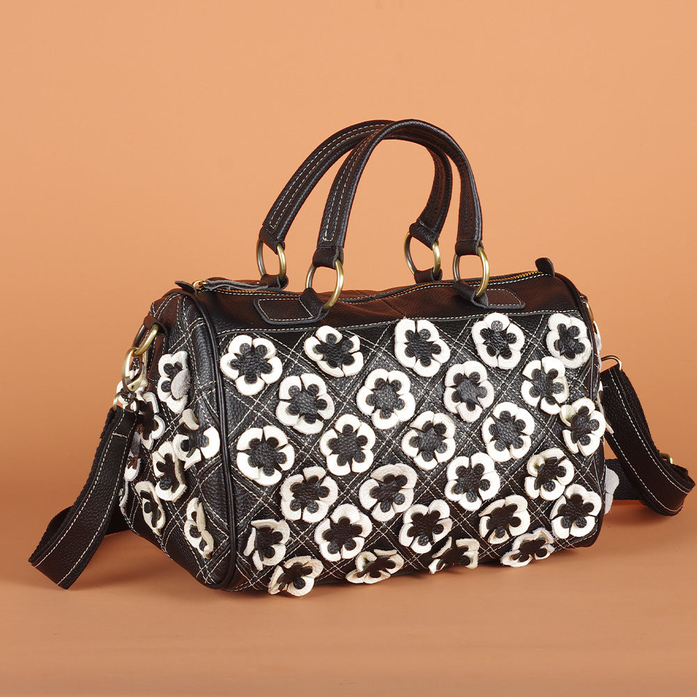 Black and white floral bag shown against a warm backdrop