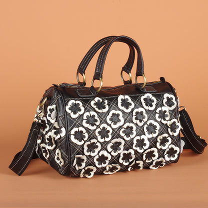 Black and white floral bag shown against a warm backdrop
