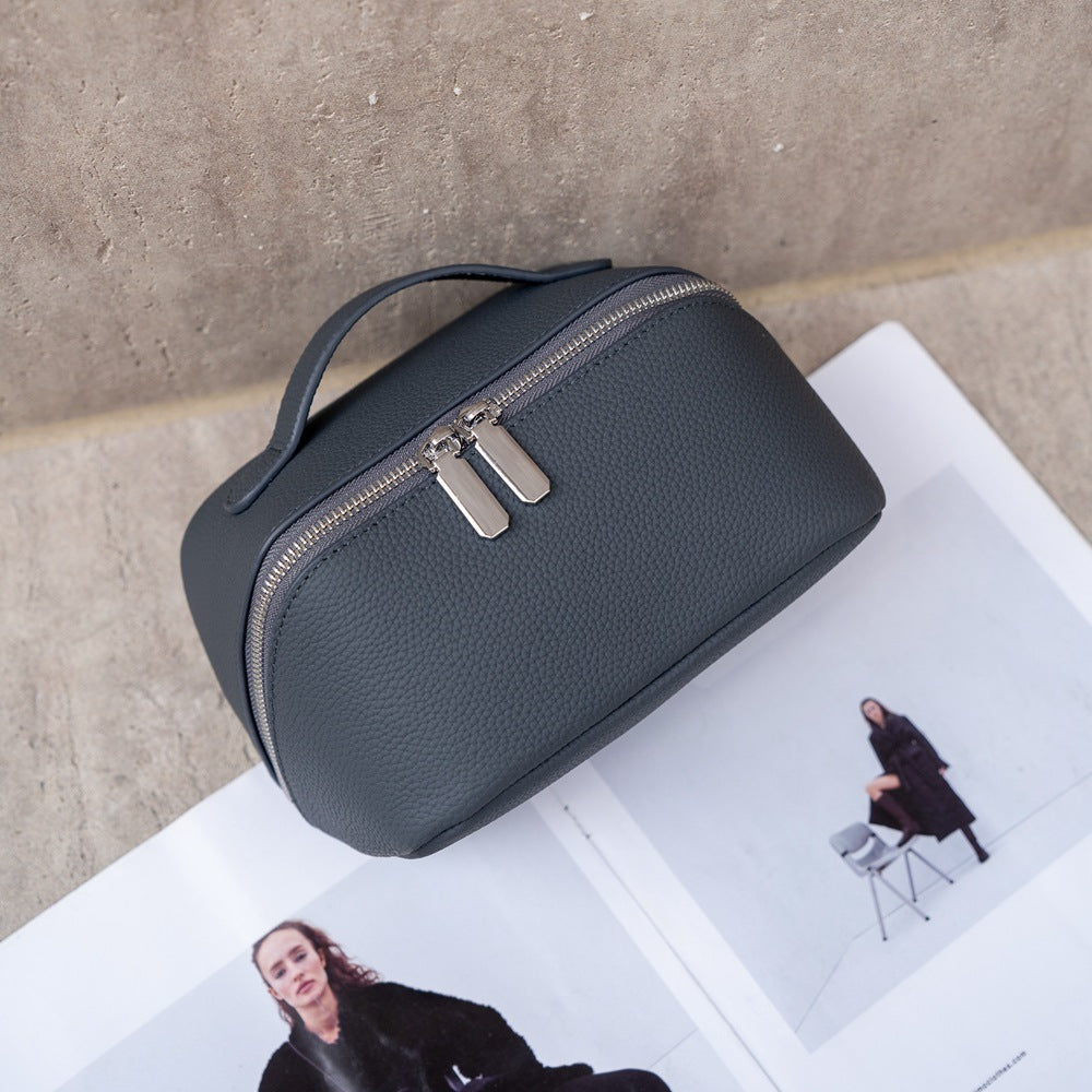 Deep gray-blue cosmetic pouch with stitched leather exterior