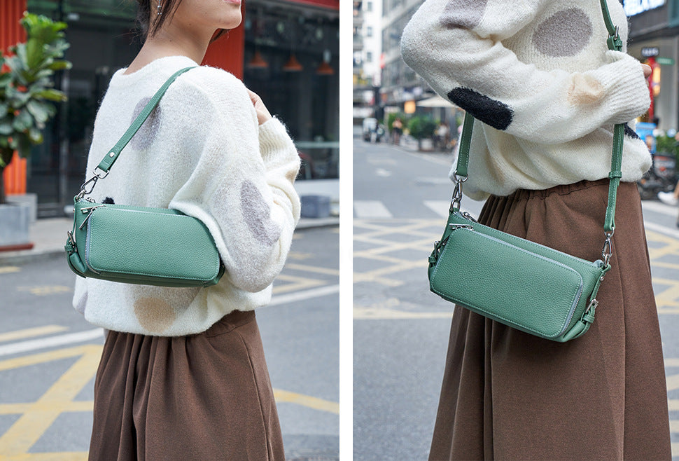 Green leather crossbody bag worn by model on street