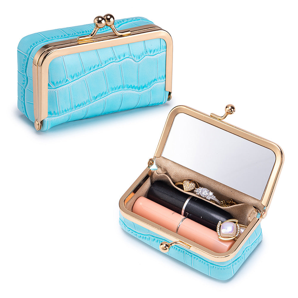 Blue crocodile-embossed pouch opened with mirror