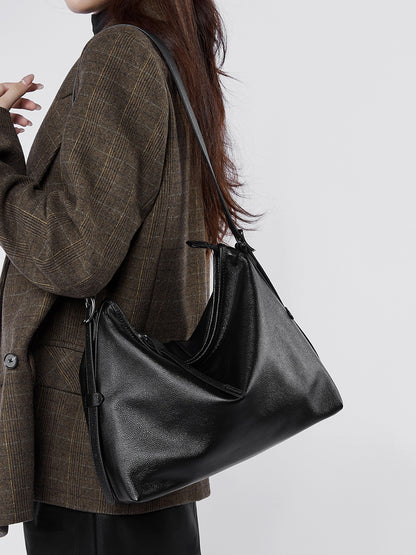 Black leather bag worn crossbody on a model